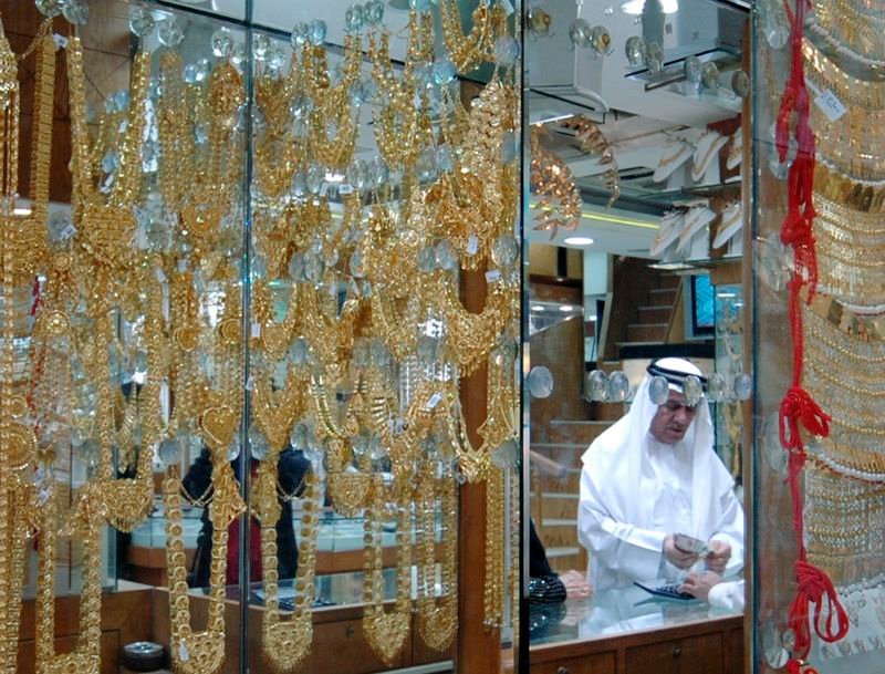 © Reuters. FILE PHOTO: A man pays for his purchase in a shop at the Gold Souq in Dubai January 16, 2008. REUTERS/Jumana El Heloueh/File Photo